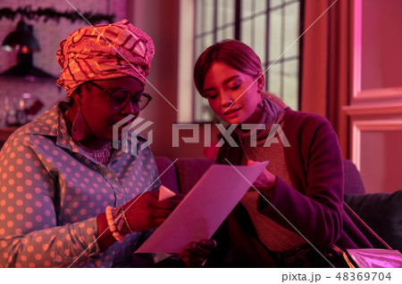 Young long-haired young woman with long earrings looking interested Young long-haired young woman with long earrings looking interested 48369704