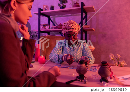 African american plump fortune-teller with a huge ring looking serious 48369819