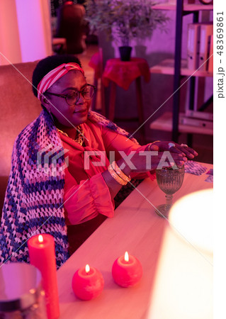 African american plump fortune-teller with a golden watch looking contented 48369861