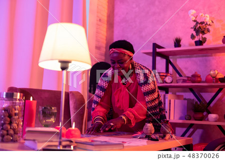 African american plump fortune-teller with huge earrings looking pleased African american plump fortune-teller with huge earrings looking pleased 48370026
