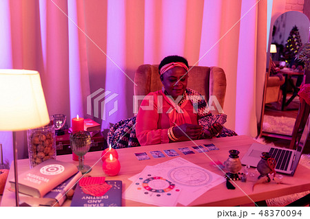 African american plump fortune-teller in ethnic adornments reading cards Tarot 48370094