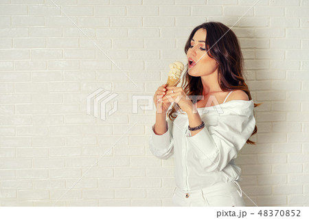 Sexy young woman eats ice cream cone. Retro toning 48370852