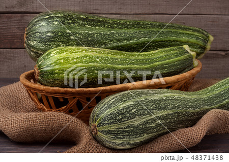 green zucchini or courgettes on sackcloth wooden background green zucchini or courgettes on sackcloth wooden background 48371438