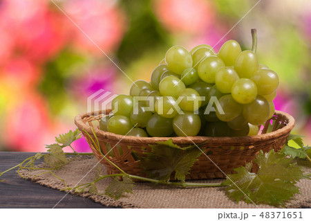 bunch of ripe green grapes on a wooden table with blurred background bunch of ripe green grapes on a wooden table with blurred background 48371651