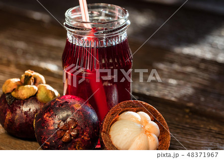 Fresh Mangosteen fruit and drink in jar on wooden background 48371967