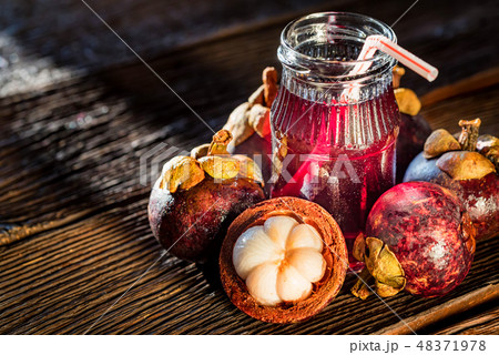 Fresh Mangosteen fruit and drink in jar on wooden background 48371978