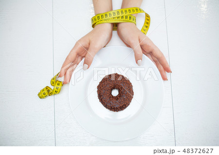 Diet or weight control concept. Centimeter tape and fork on a white background with a place for 48372627