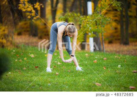 Sport outdoor. Sporty young woman in sportswear doing stretching after fitness exercises Sport outdoor. Sporty young woman in sportswear doing stretching after fitness exercises 48372685