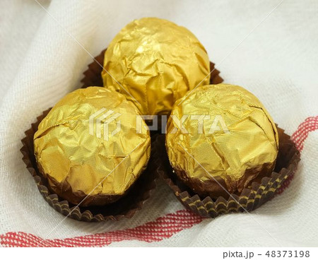 Brown Round Chocolate Candies in Gold Package 48373198
