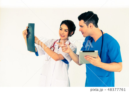 Doctors working with x ray film of patient head. 48377761