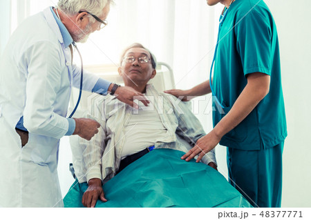 Mature doctor and senior patient in hospital ward. Mature doctor and senior patient in hospital ward. 48377771