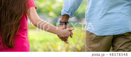 Father and daughter holding hands in the park. 48378348