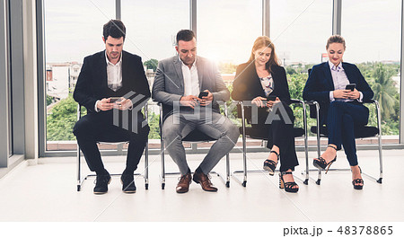 Businesswomen and businessmen using mobile phone. Businesswomen and businessmen using mobile phone. 48378865