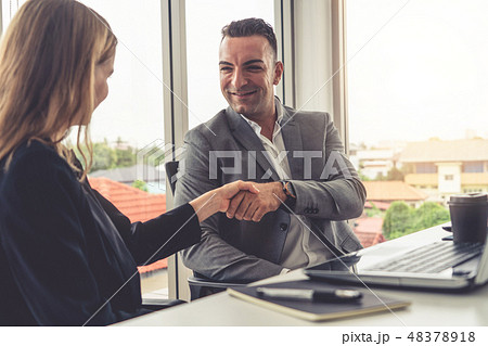 Businessman handshake businesswoman in office. Businessman handshake businesswoman in office. 48378918