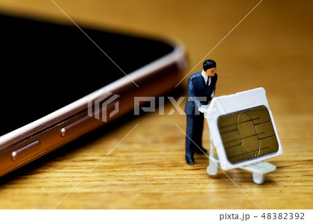 スマートホンからSIMカードを抜き取り運ぶ男性 スマートホンからSIMカードを抜き取り運ぶ男性 48382392