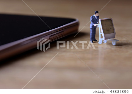 スマートホンからSIMカードを抜き取り運ぶ男性 スマートホンからSIMカードを抜き取り運ぶ男性 48382396