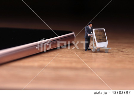 スマートホンからSIMカードを抜き取り運ぶ男性 48382397