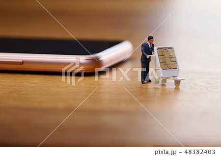 スマートフォンからSIMカードを抜き取り運ぶ男性 48382403