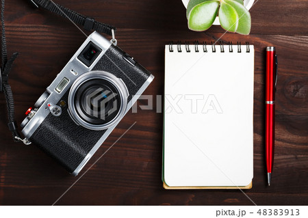 Classic camera with blank notepad page and red pen 48383913