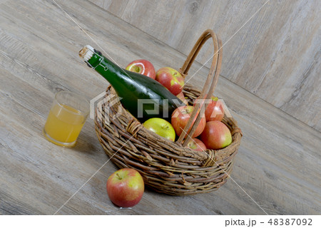 apple basket and bottle of cider 48387092