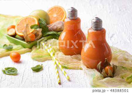 Two cups of orange and ginger smoothie with fruit 48388501