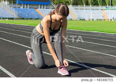 young beautiful sport runner woman tying her shoe 48388755