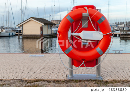 Red lifebuoy placed on a lake coast 48388889