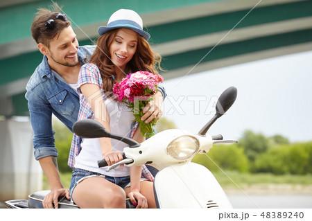 A man gives flowers beautiful woman. In the background the river 48389240