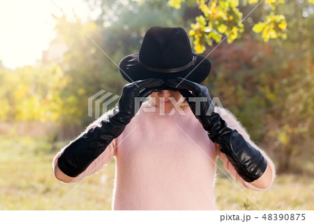 Woman holding hat 48390875
