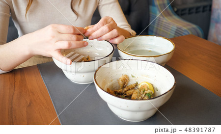 female hands cleans and eats shrimp in cafe 48391787