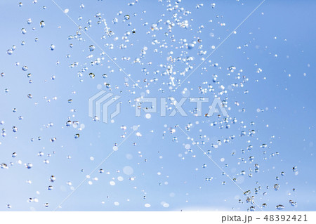 Water drops in the air against the sky Water drops in the air against the sky 48392421