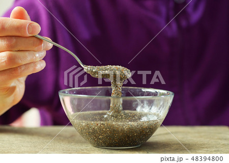 Woman hand with spoon of chia seeds Woman hand with spoon of chia seeds 48394800