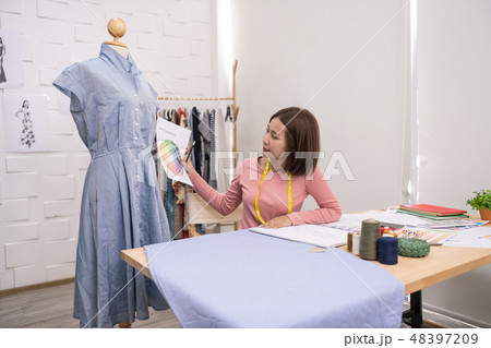 Designer concept. The dressmaker is designing an evening dress i Designer concept. The dressmaker is designing an evening dress i 48397209