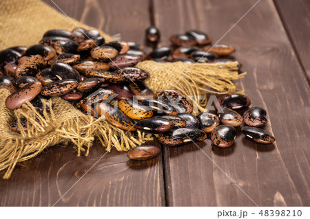 Speckled colored butter beans on brown wood 48398210