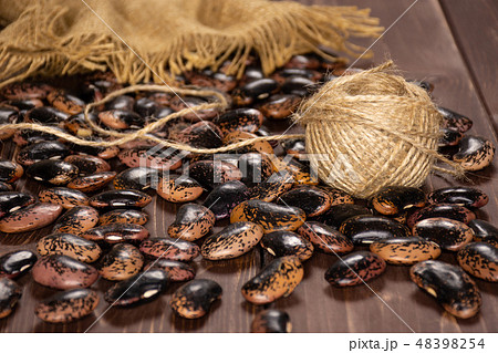 Speckled colored butter beans on brown wood Speckled colored butter beans on brown wood 48398254