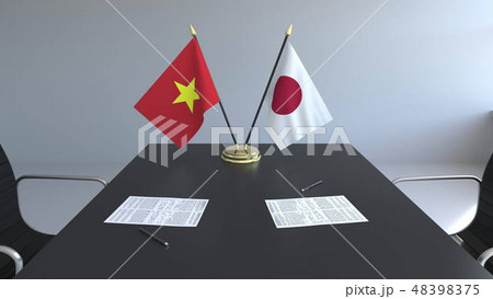 Flags of Vietnam and Japan and papers on the table. Negotiations and signing an international Flags of Vietnam and Japan and papers on the table. Negotiations and signing an international 48398375