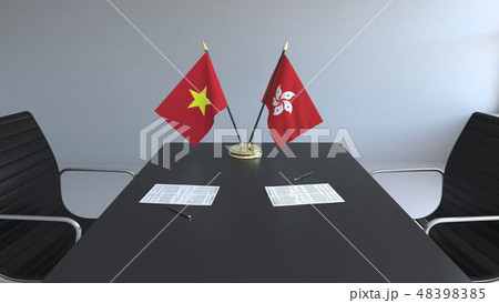 Flags of Vietnam and Hong Kong and papers on the table. Negotiations and signing an international 48398385