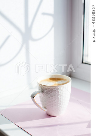White cup of coffee on the table in sunlight 48398857