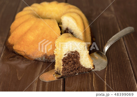 baked marble gugelhupf sweet bread on brown wood 48399069