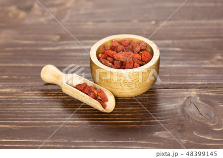 Dried red goji berries on brown wood Dried red goji berries on brown wood 48399145