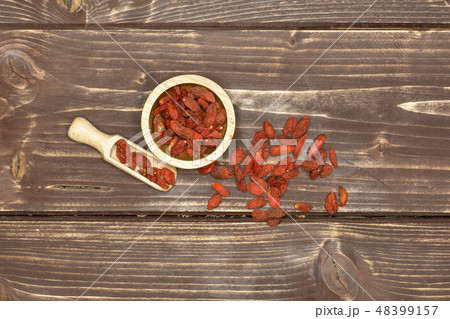 Dried red goji berries on brown wood 48399157