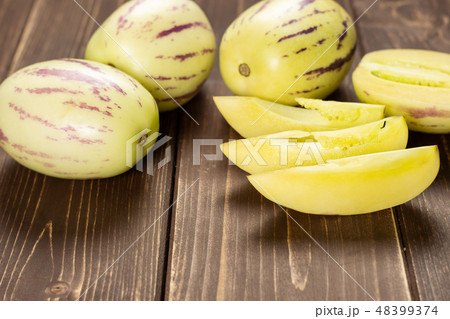 Fresh striped pepino melon on brown wood Fresh striped pepino melon on brown wood 48399374