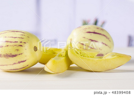 Fresh striped pepino melon with red tulips 48399408
