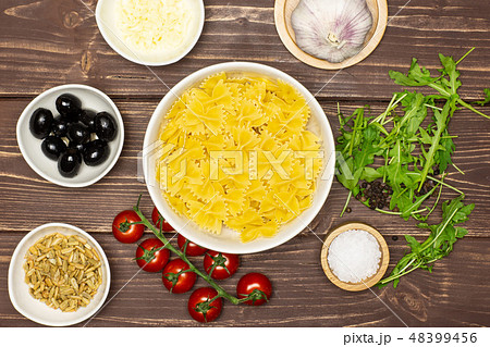 farfalle with arugula leaves on brown wood farfalle with arugula leaves on brown wood 48399456