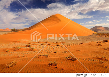 Big orange dune with blue sky and clouds 48400492