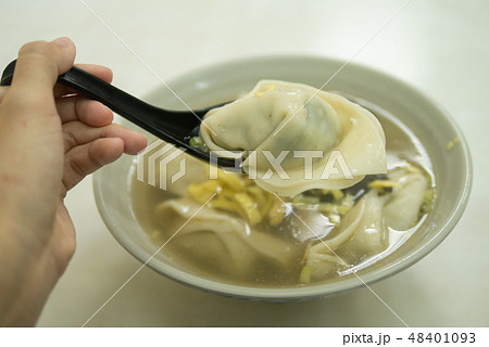 Hand holding spoon with wonton dumpling soup 48401093