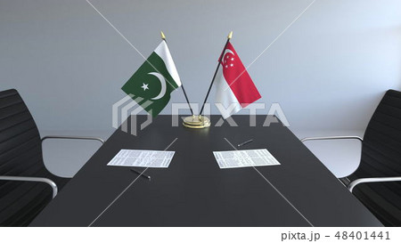Flags of Pakistan and Singapore and papers on the table. Negotiations and signing an international Flags of Pakistan and Singapore and papers on the table. Negotiations and signing an international 48401441