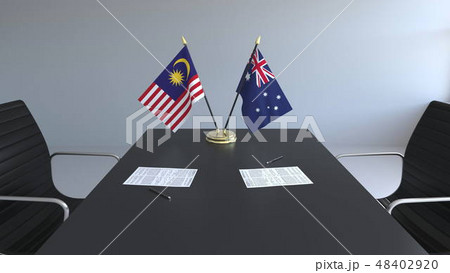 Flags of Malaysia and Australia and papers on the table. Negotiations and signing an international Flags of Malaysia and Australia and papers on the table. Negotiations and signing an international 48402920