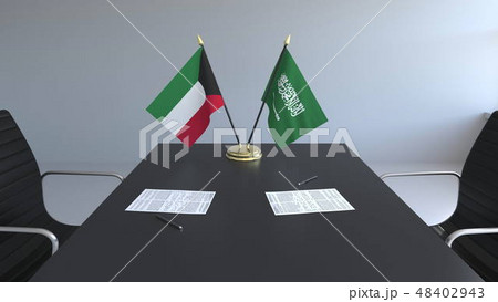 Flags of Kuwait and Saudi Arabia and papers on the table. Negotiations and signing an international Flags of Kuwait and Saudi Arabia and papers on the table. Negotiations and signing an international 48402943