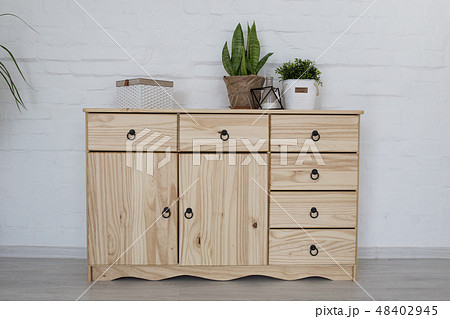 Interior living room with a wooden chest on a white brick wall 48402945